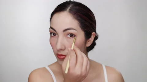 Makeup Tutorial: Attractive model demonstrates eye shadow application on eyes Stock Footage 193655110