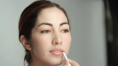 Makeup tutorial: beautiful brunette in studio uses lip liner slow motion Stock-Footage 194434909