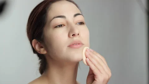 Makeup tutorial: Beautiful latina model uses pressed powder on chin and cheek Stock Footage 193858415