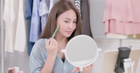 A makeup tutorial is being filmed by a beauty blogger using a tripod. Influencer Stock Footage 213566848