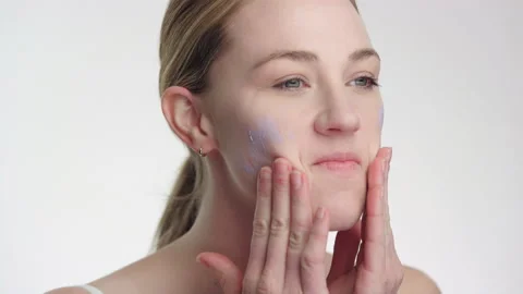 Makeup tutorial: blonde woman applies foundation to face slow motion 4K Stock Footage 193985857
