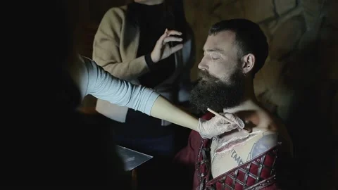 Makeup woman makes makeup in form of torn bloody wound on man Video stock 132992074
