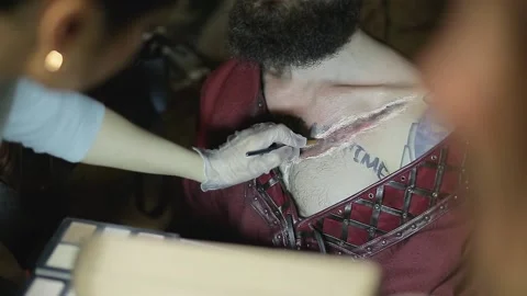 Makeup woman makes makeup in form of torn bloody wound on man Video stock 132992084