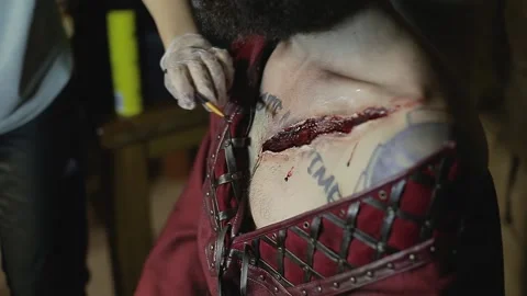 Makeup woman makes makeup in form of torn bloody wound on man Video stock 132992092