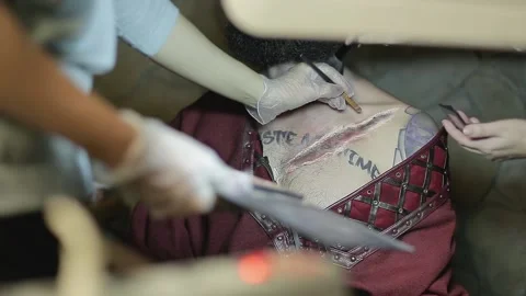 Makeup woman makes makeup in form of torn bloody wound on man Video stock 132992093
