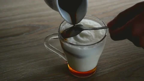 Making 2 layer coffee at home. Coffee liquor pouring into the milk 動画素材 150505646