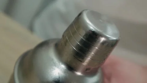 Making alcoholic cocktail. The bartender removes the lid from the shaker Stock Footage 131539862