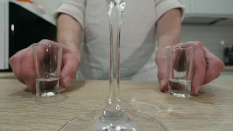 Making an alcoholic cocktail. The bartender stands behind the counter at home an Stock Footage 131537402