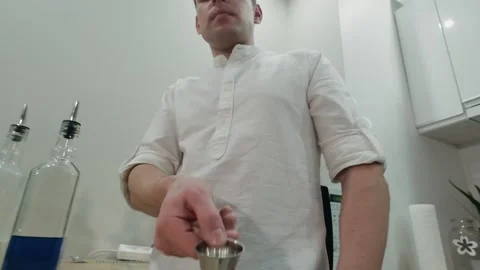 Making alcoholic cocktail. The bartender throws jigger and catch. Zoom out Stock Footage 131542911