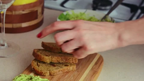 Making avocado toast. Man spread avocado on toasted sandwich bread Stock Footage 171812104