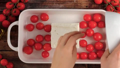 Making baked feta cheese with cherry tomatoes, herbs and olive oil Stock Footage 242524401