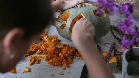 Making beautiful autumn lantern from pumpkin, scooping out all the pulp from Stock Footage 250236413