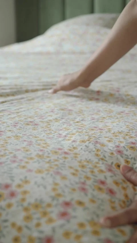 Making a bed with floral sheets in a bedroom Stock Footage 340597087