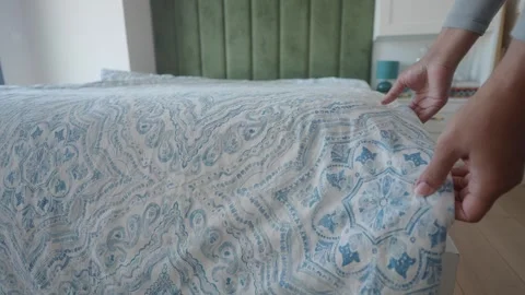 Making the bed with a stylish quilt and decorative touches Stock Footage 312540282