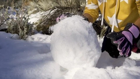 Making a big snowball Stockbeeldmateriaal 100888302