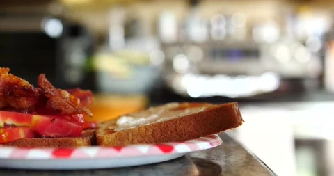 Making a BLT sandwich placing the bacon, lettuce and tomato on top Stock Footage 206574149