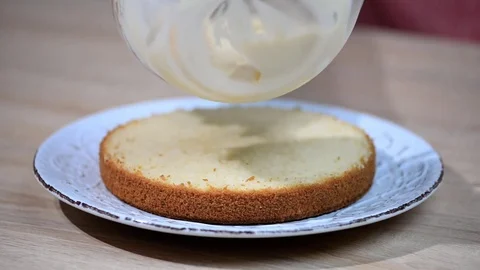 Making of Boston Cream Pie. Hand putting cream on freshly baked cake Stock Footage 80533189