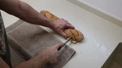 Making bread with hands at a kitchen counter with a knife and towel around 库存影片 323606044