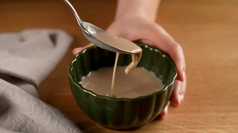 Making Bread - mixing the yeast mixture with the spoon in slow motion 4K Stock Footage 265886958