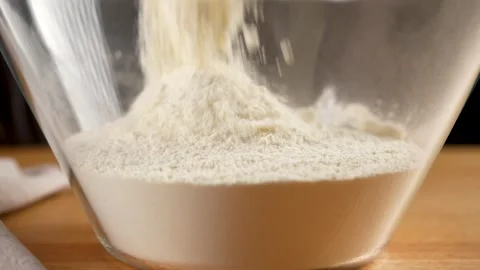 Making Bread - pouring flour into a glass bowl close-up view in slow motion 4K Stock Footage 265887528