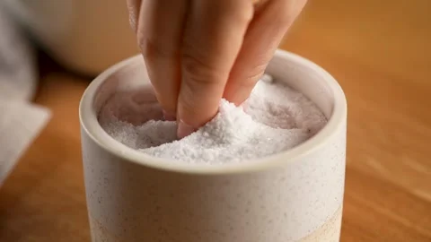 Making Bread - taking coarse salt from a container in slow motion 4K Stock Footage 265887470