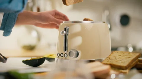 Making breakfast with a classic toaster in a cozy kitchen setting Stock Footage 305346376