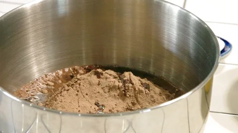 Making Brownie batter in a stainless steel bowl with power mixer Stock Footage