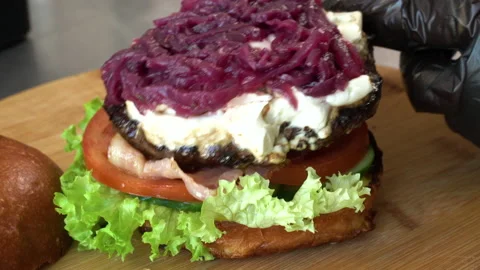 Making burger close-up, the hand of a chef in black gloves prepares a burger or Video stock 179317297