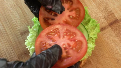 Making burger close-up, the hand of a chef in black gloves prepares a burger or Video stock 179321945