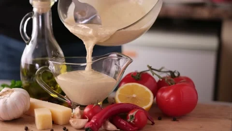 Making Caesar salad sauce - pouring sauce in a glass gravy boat Vídeos de archivo 198134010