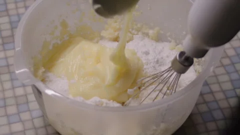 Making the cake cream, adding the ingredients to a plastic bowl with a hand Stock Footage 311058276
