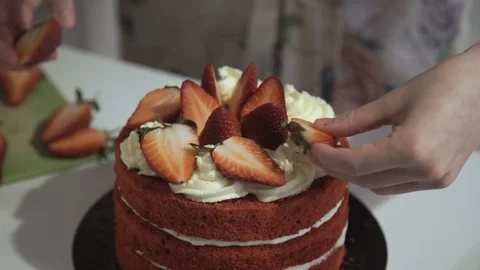 Making cake at home. Decoration of the cake with strawberries. Table white Stock Footage 106438902
