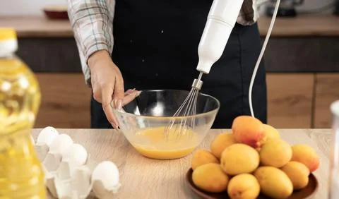 Making cake using a mixer to mix eggs for apricot pie Stock Photos