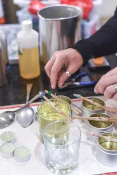 Making candles at home and adding a wick to liquid candle wax Stock Photos