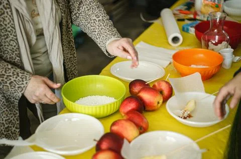 Making candy apples with caramel and sprinkles for a sweet snack Фото