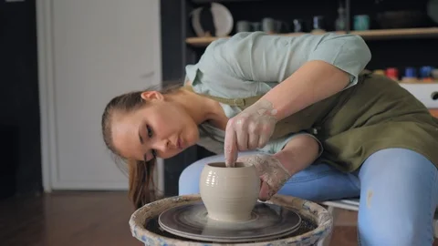 Making ceramic products from white clay.  Girl in pottery studio 库存影片 119543144