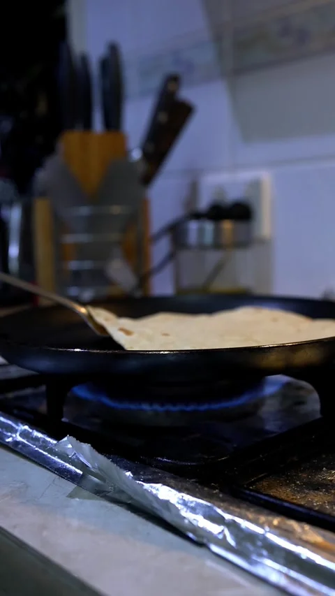 Making chapati flatbread on stovetop in home kitchen Stock Footage 343876186