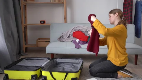 Making check list of things for travel. Woman packing suitcase to vacation and Stock Footage 233671124