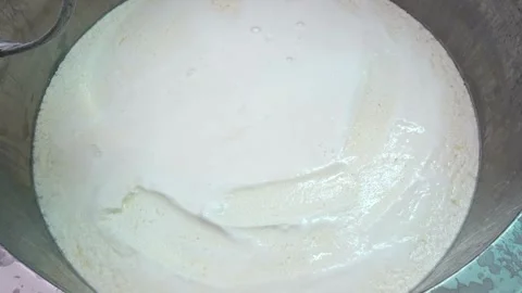 Making Cheese Mixing of cheese inside large industrial stainless steel tank Stock Footage 336444416