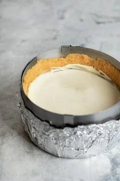 Making cheesecake in a baking form in the kitchen Stock Photos