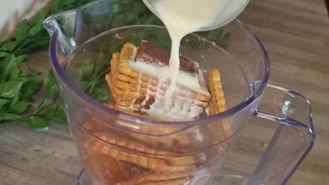 Making Chocolate Biscuit Milkshake | Adding Milk to Blender Stock Footage 345313720