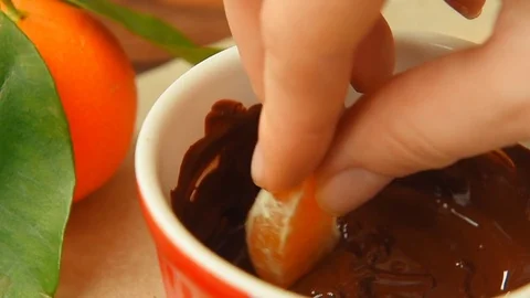 Making chocolate-dipped mandarin slices Stock Footage 70139573