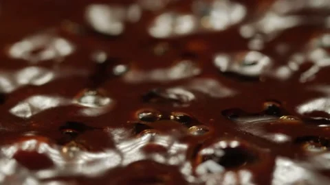 Making chocolate. Macro shot of bubbles in boiling thick dark brown liquid Stock Footage 167989737
