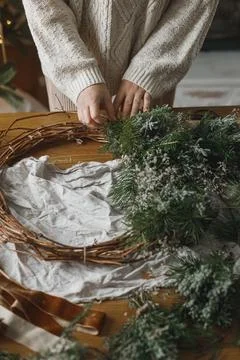 Making Christmas rustic wreath. Hands holding evergreen branches, making wr.. Stock Photos