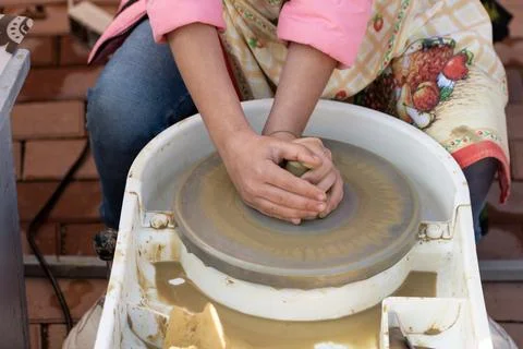 Making A Clay Pot On The Pottery Class. Woman Potter working on potters whe.. Stock Photos