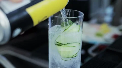 Making a cocktail, the bartender pours lemonade into a glass with ice and Stock Footage 314428744