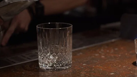 Making a cocktail, dropping ice in glass Stock Footage 124031933