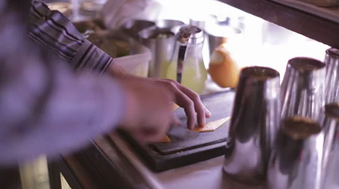 Making a Cocktail - Preparing an Orange Peel for a Cocktail Stock Footage 68978018