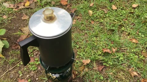 Making coffe in a percolator camping coffee pot on a mobile gas stove. Stock Footage 138578461