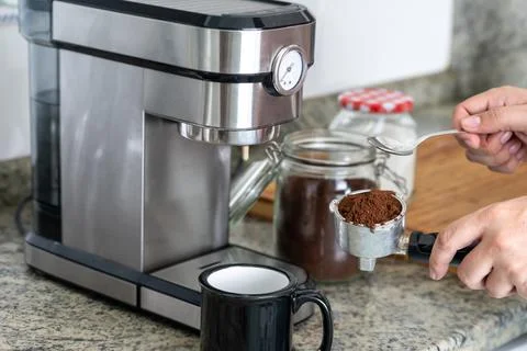 Making coffee at home with an espresso machine putting the coffee in the filter Stock Photos